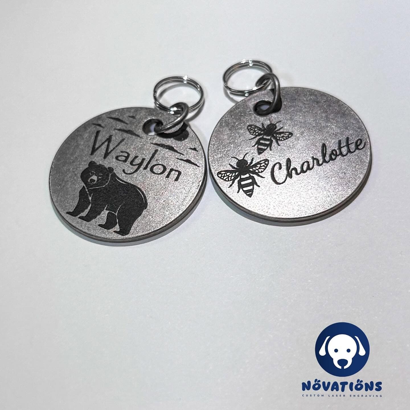 Custom personalized pet tags by Novations, featuring engraved pet names and unique decorative designs for pets in antique silver