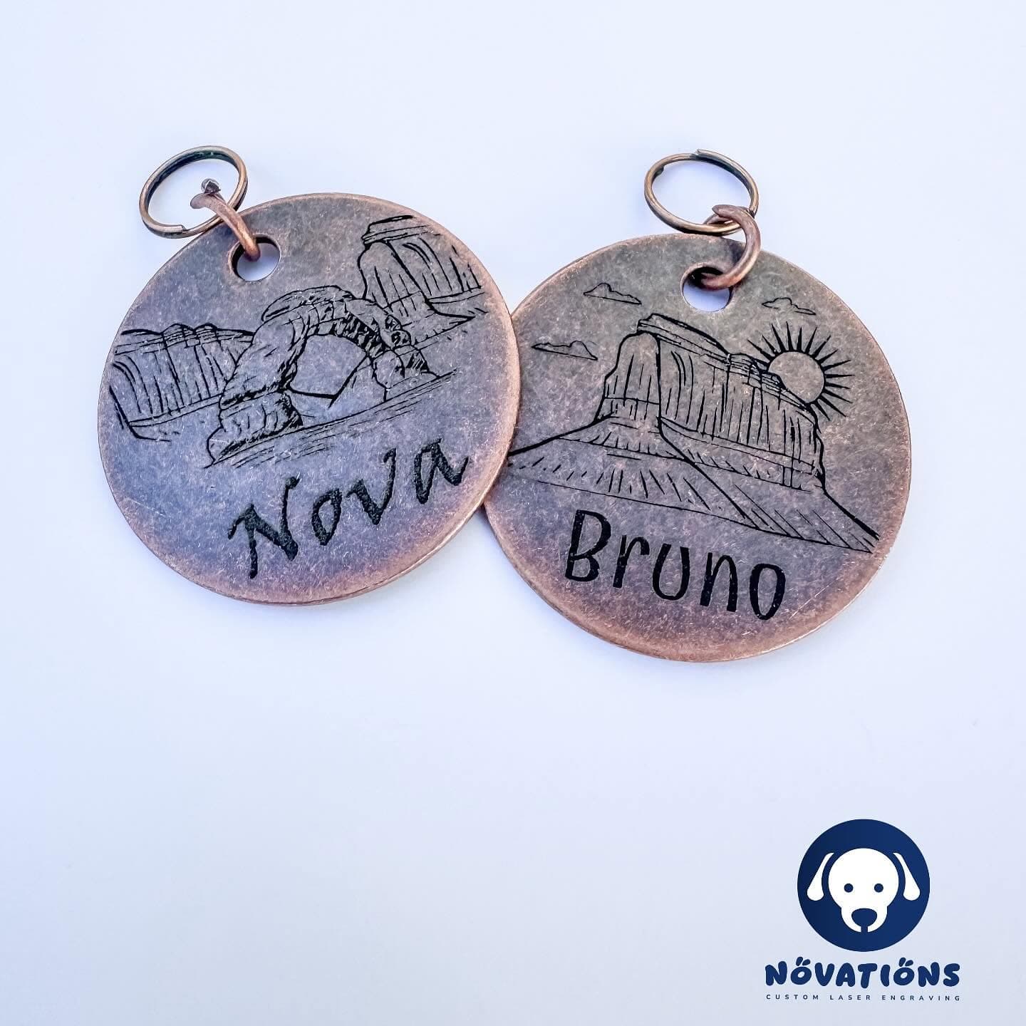 Custom personalized pet tags by Novations, featuring engraved pet names and unique decorative designs for pets in antique copper
