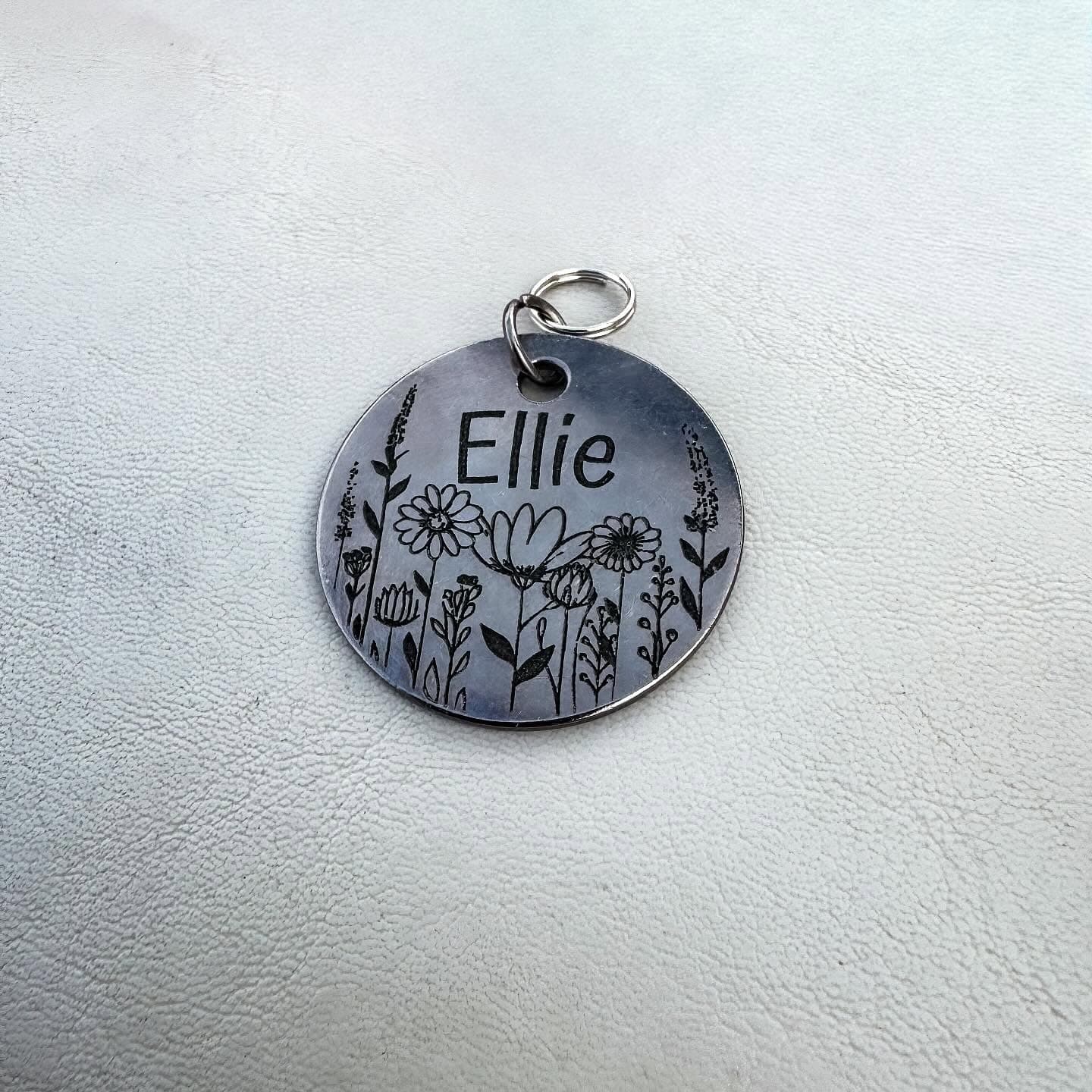 Custom personalized pet tags by Novations, featuring engraved pet name in antique silver